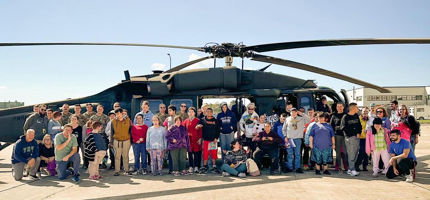 Large Group Picture of individuals in front a helicopter.